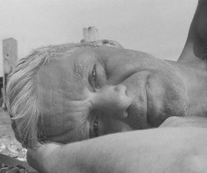 Tom Fogg, in B&W lying on the beach in a photo taken by his son.